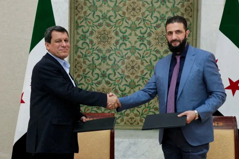 Presiden Suriah, Ahmad al-Syar’, saat menandatangani “Perjanjian 10 Maret” bersama Panglima Pasukan Demokratik Suriah (Qasad), Mazloum Abdi (Al Jazeera).